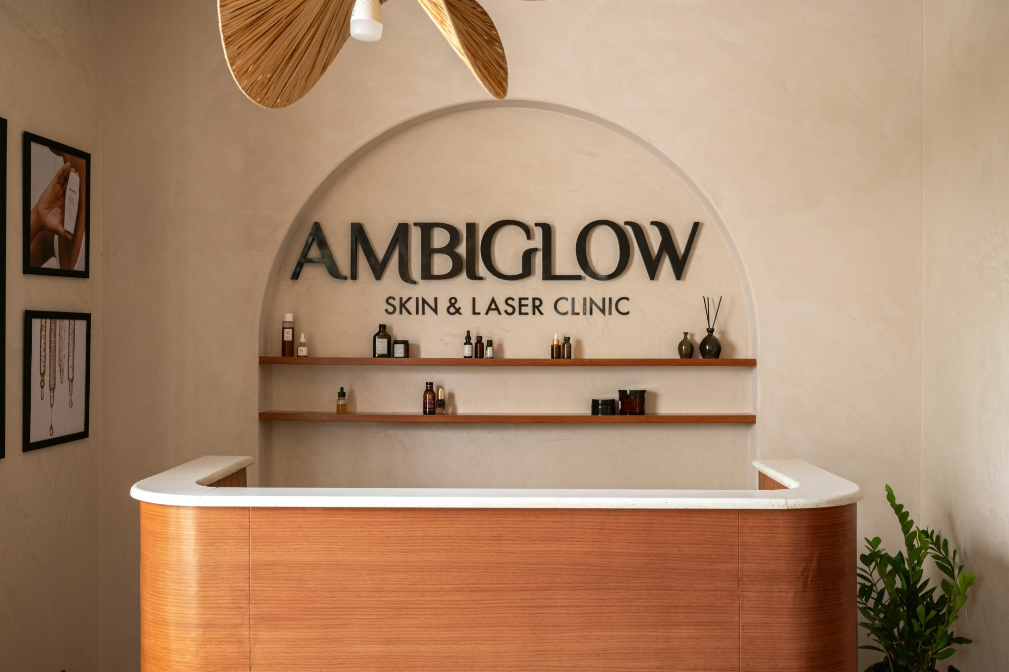 AmbiGlow reception desk in warm wood beneath a plaster arch