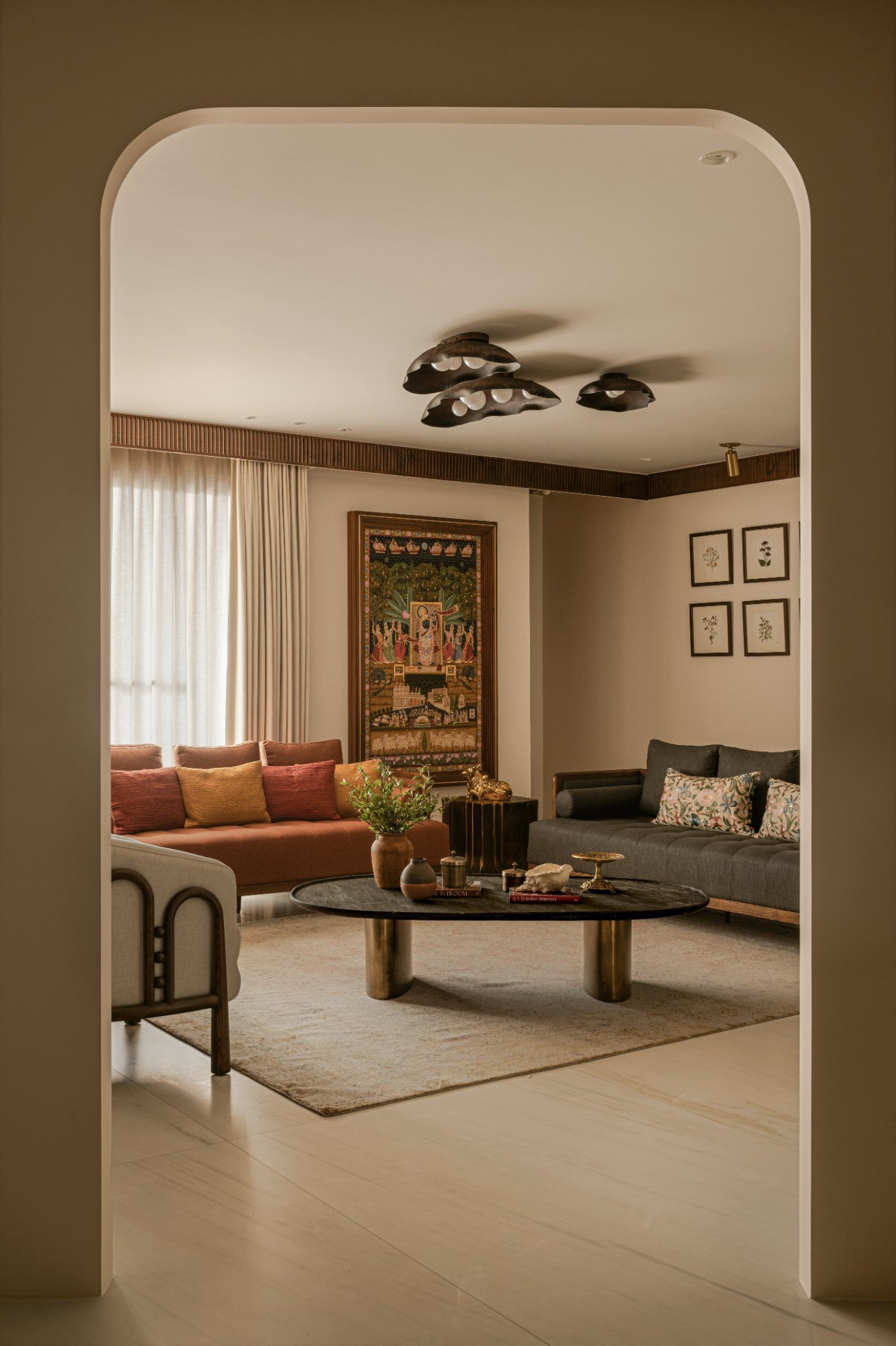 Living room seen through an arch, with terracotta and charcoal sofas