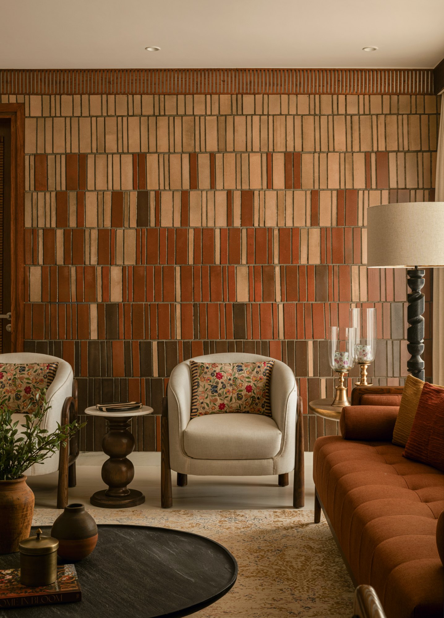 Cream armchairs in arched wooden frames against the tiled wall