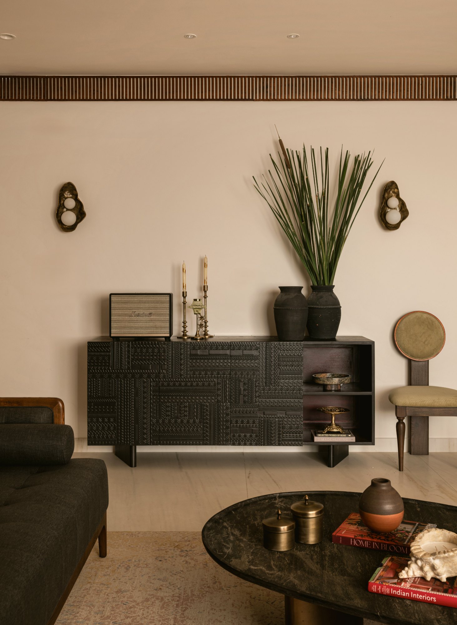 Hand-carved blackened sideboard with brass candlesticks and black urns