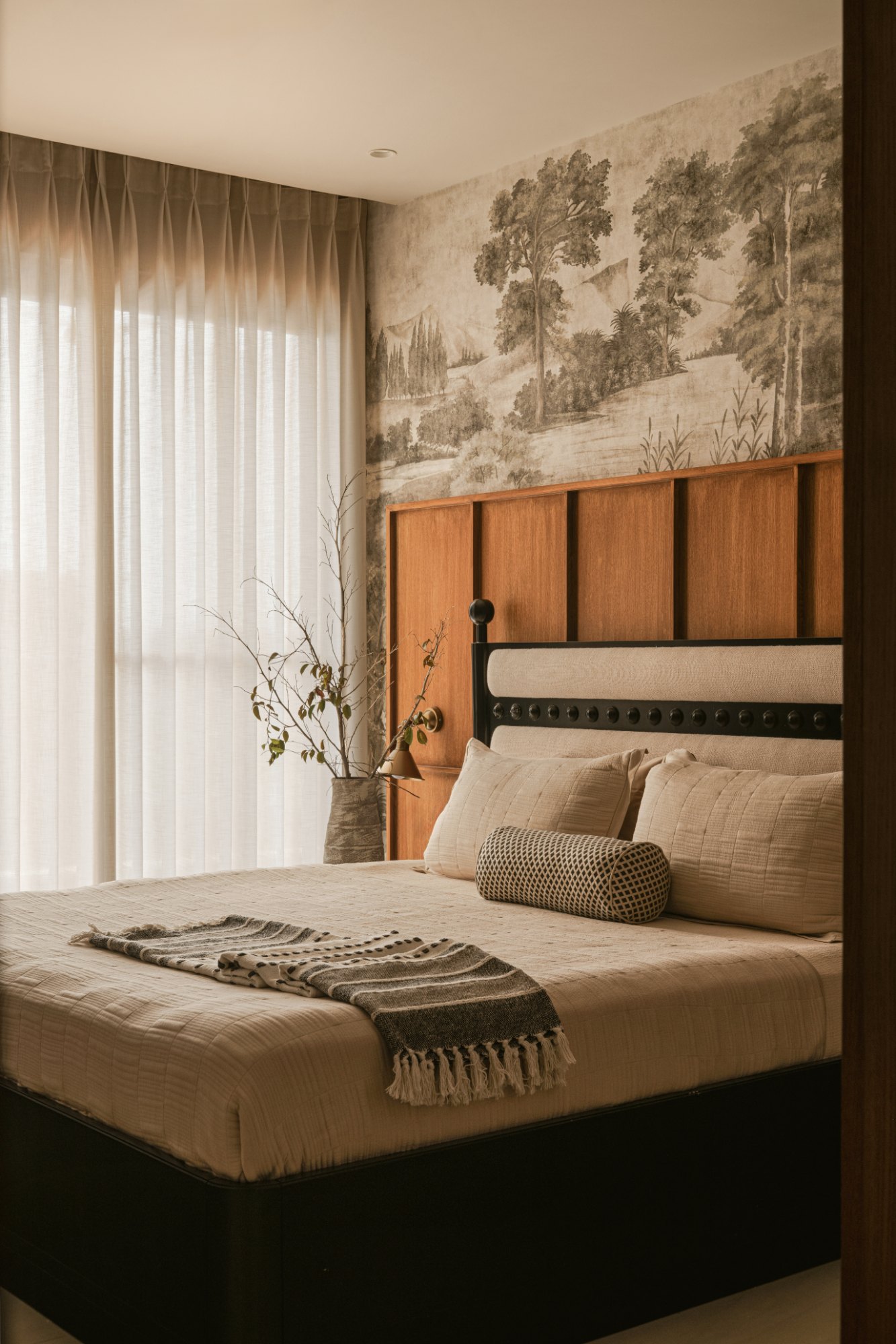 Primary bedroom with hand-painted landscape mural and panelled teak headboard wall