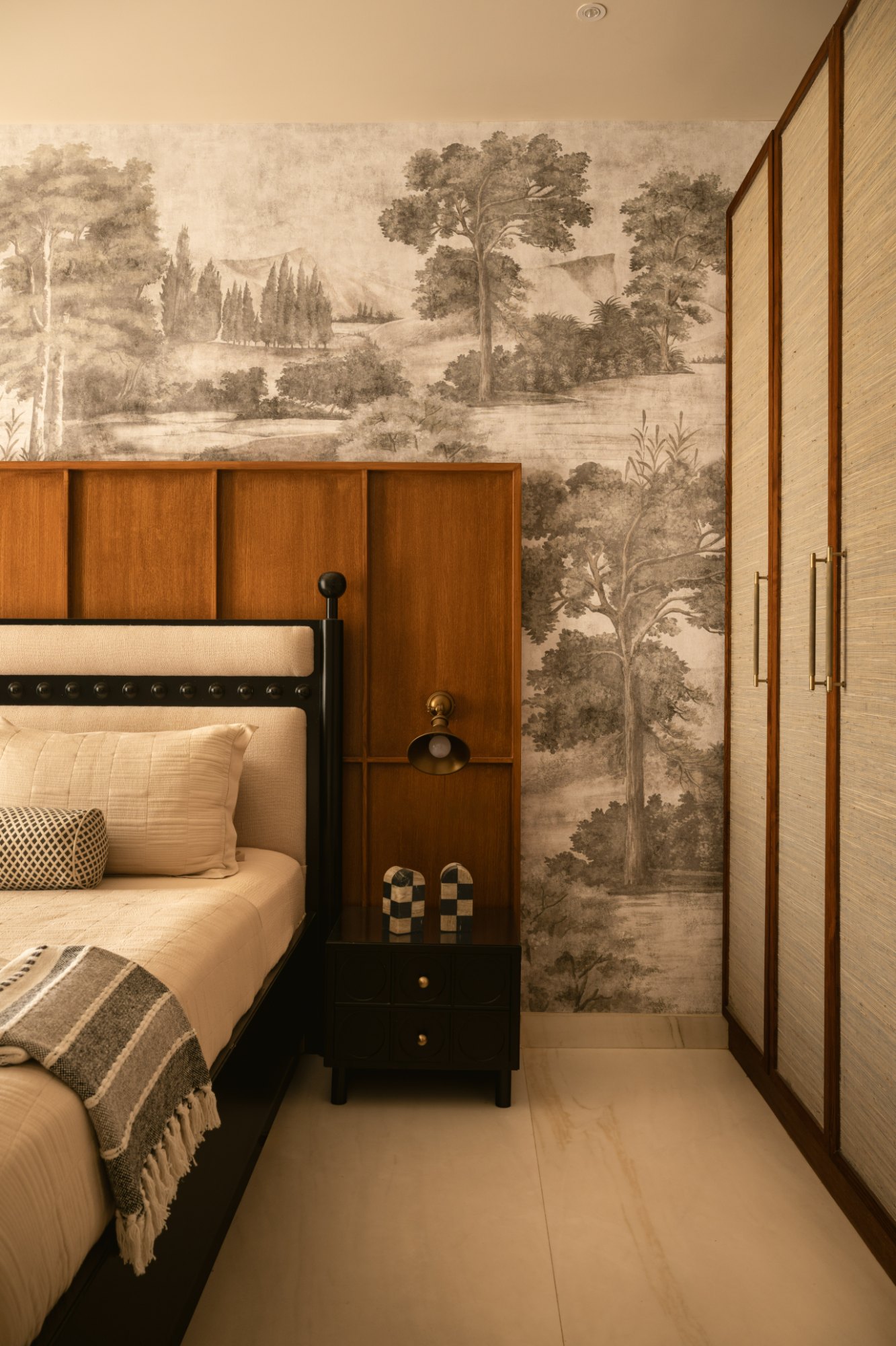 Bedside detail with brass wall light, checkered marble objects and grasscloth wardrobes