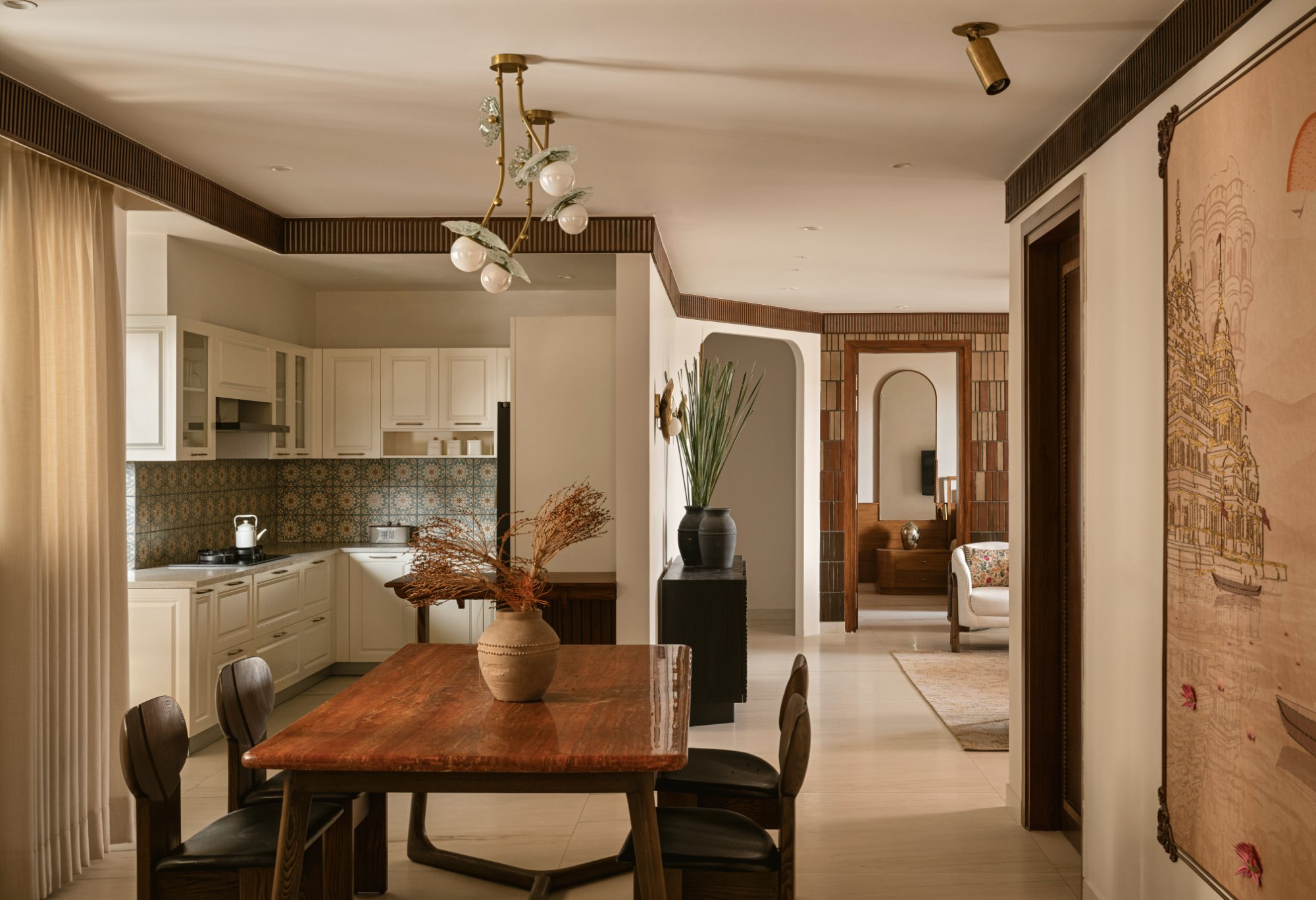 Dining table and kitchen with patterned tile backsplash, seen along the apartment's main axis