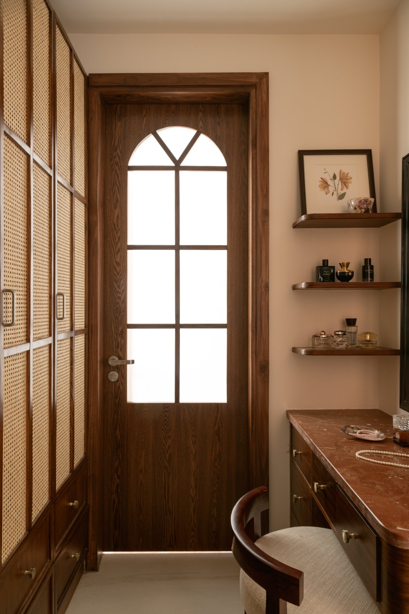 Dressing room with cane wardrobe doors, arched glazed door and a red stone vanity