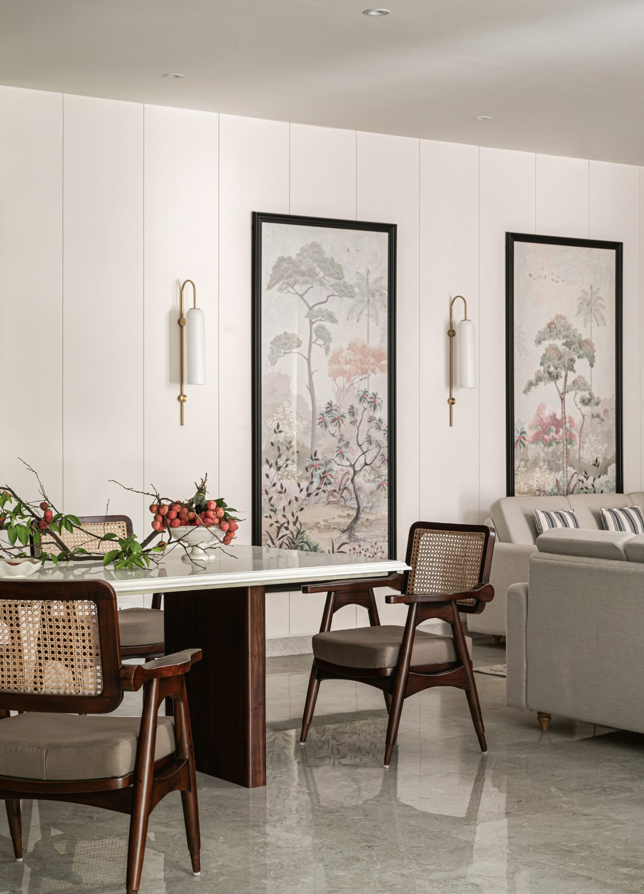 Dining area with cane-backed chairs and botanical wall panels