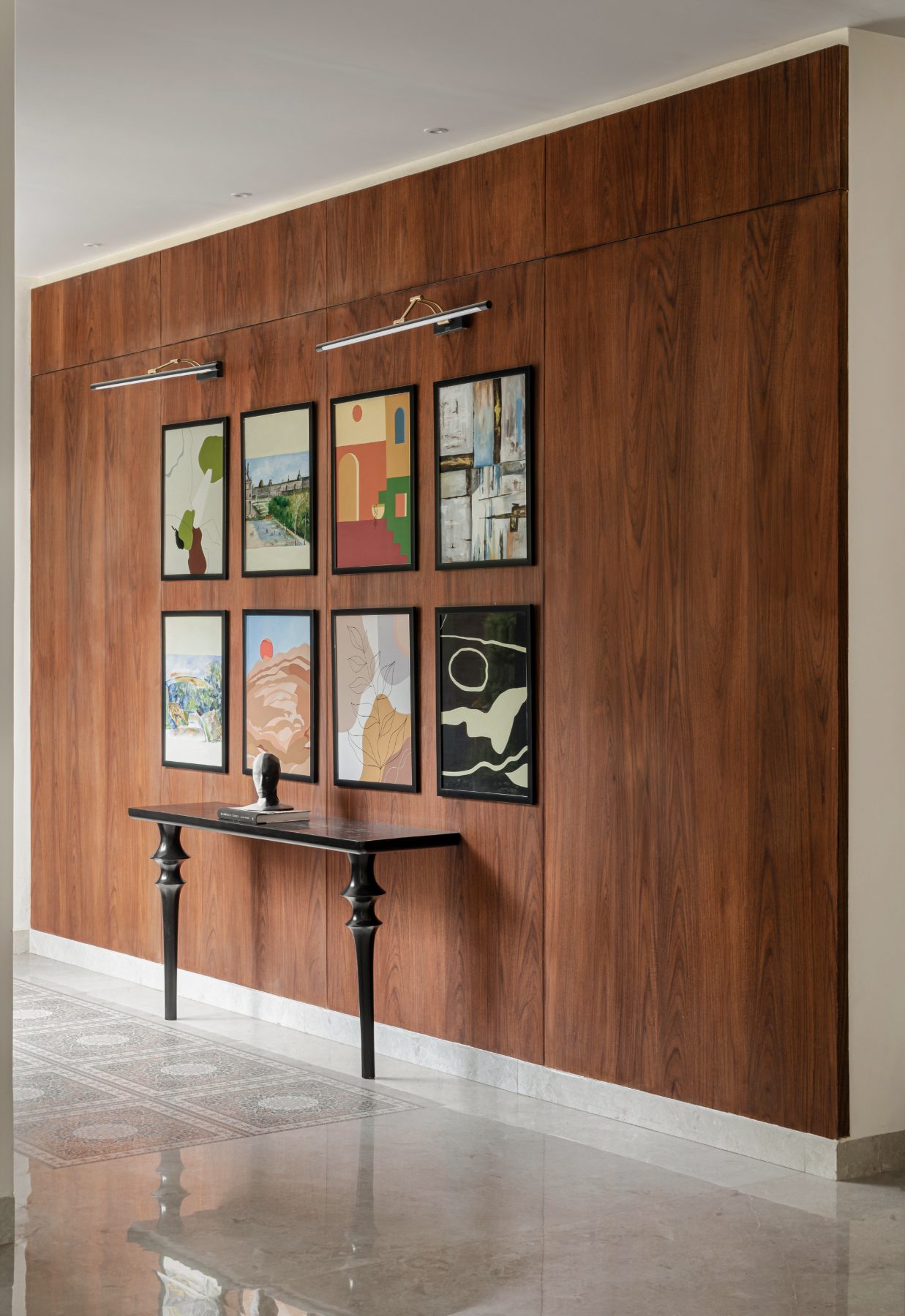 Foyer gallery wall panelled in warm wood with framed art
