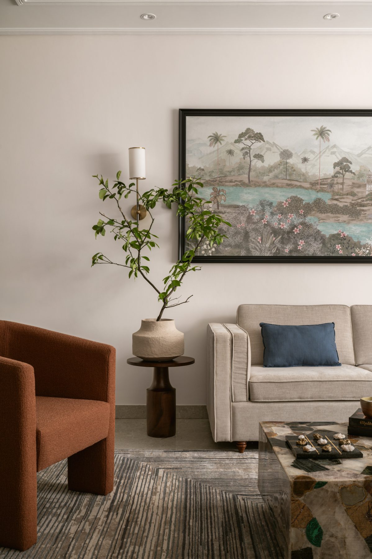 Living room corner with rust bouclé chair and mural