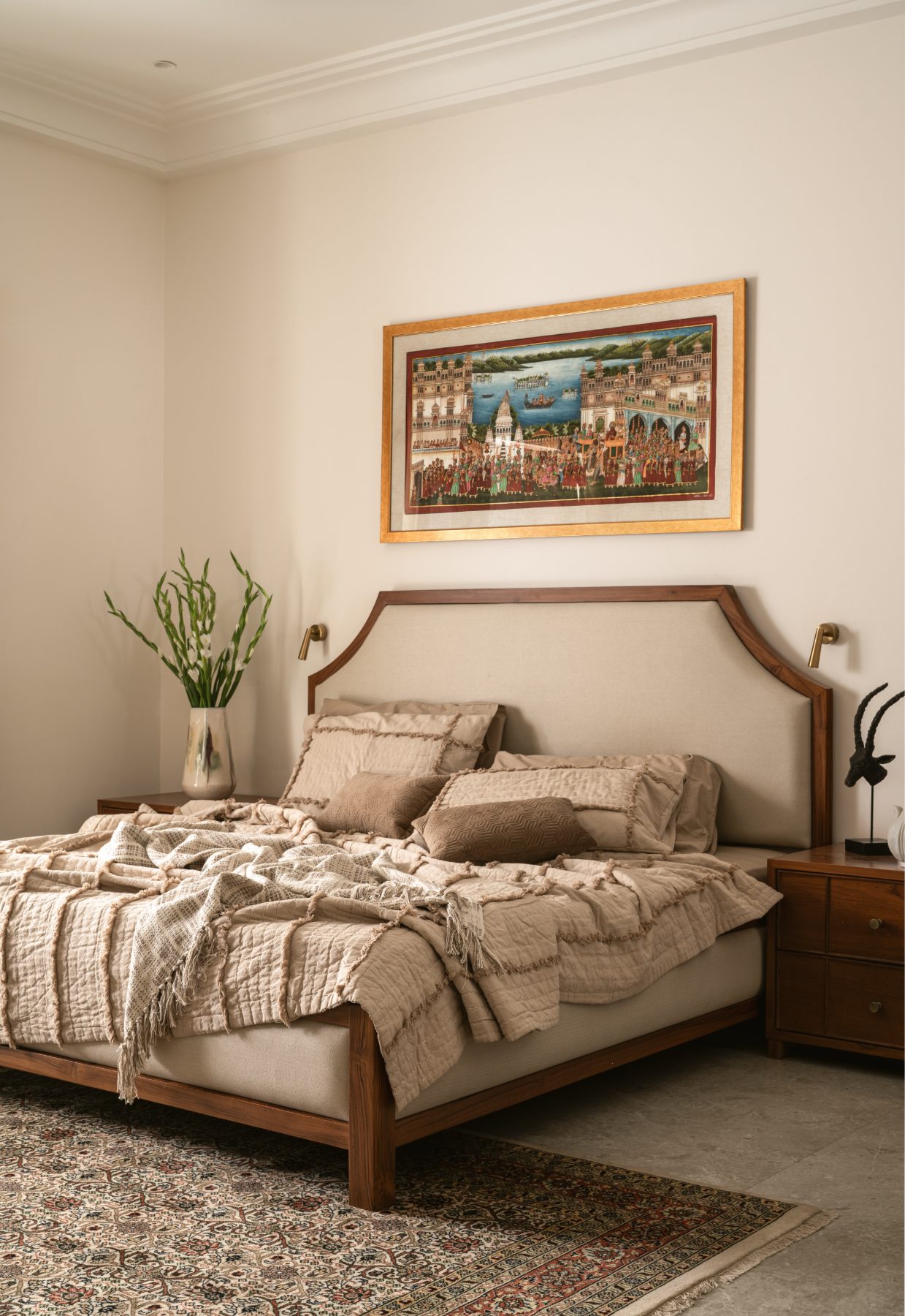 Principal bedroom with upholstered bed and pichwai painting