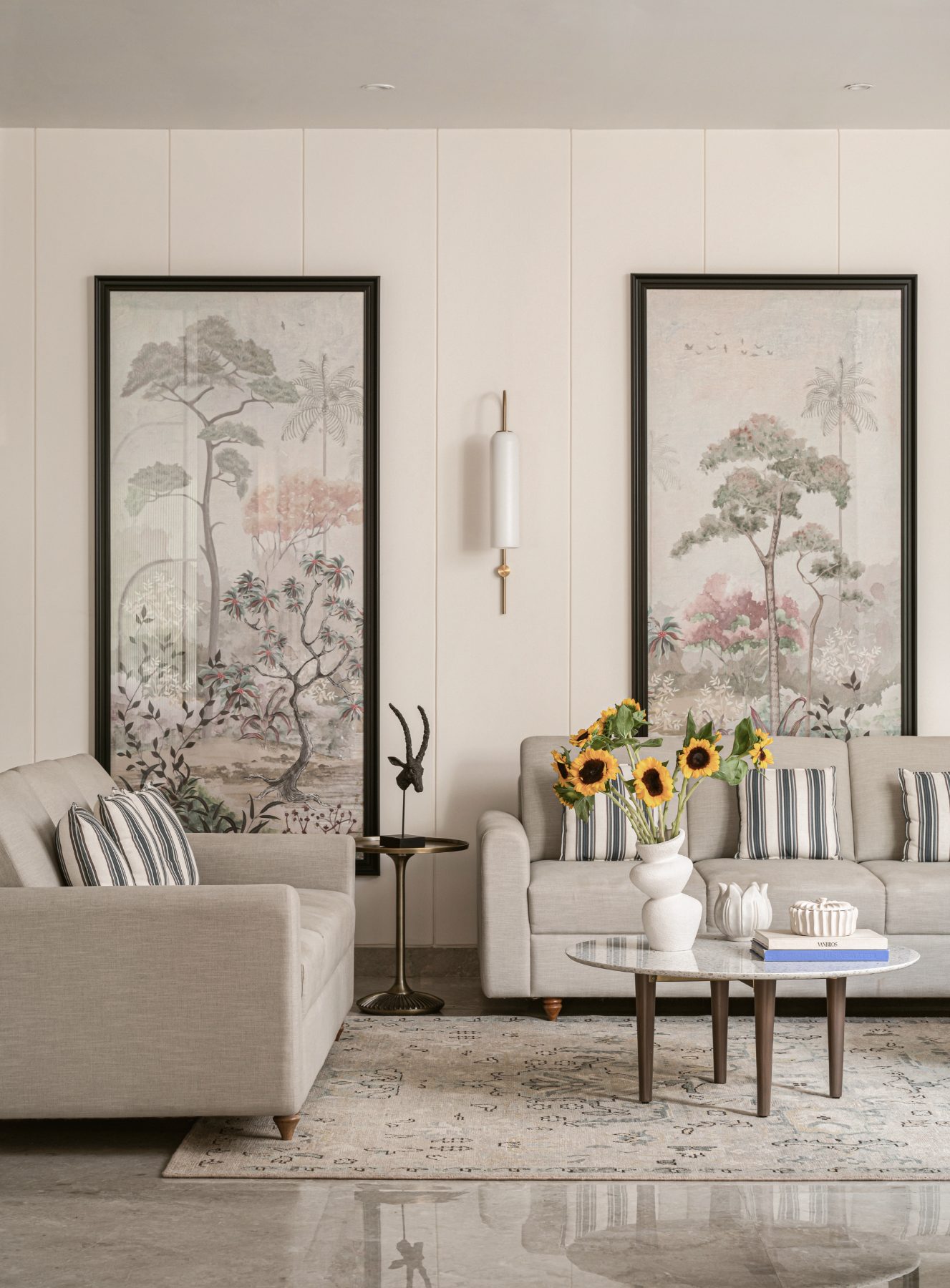 Twin linen sofas beneath framed chinoiserie panels