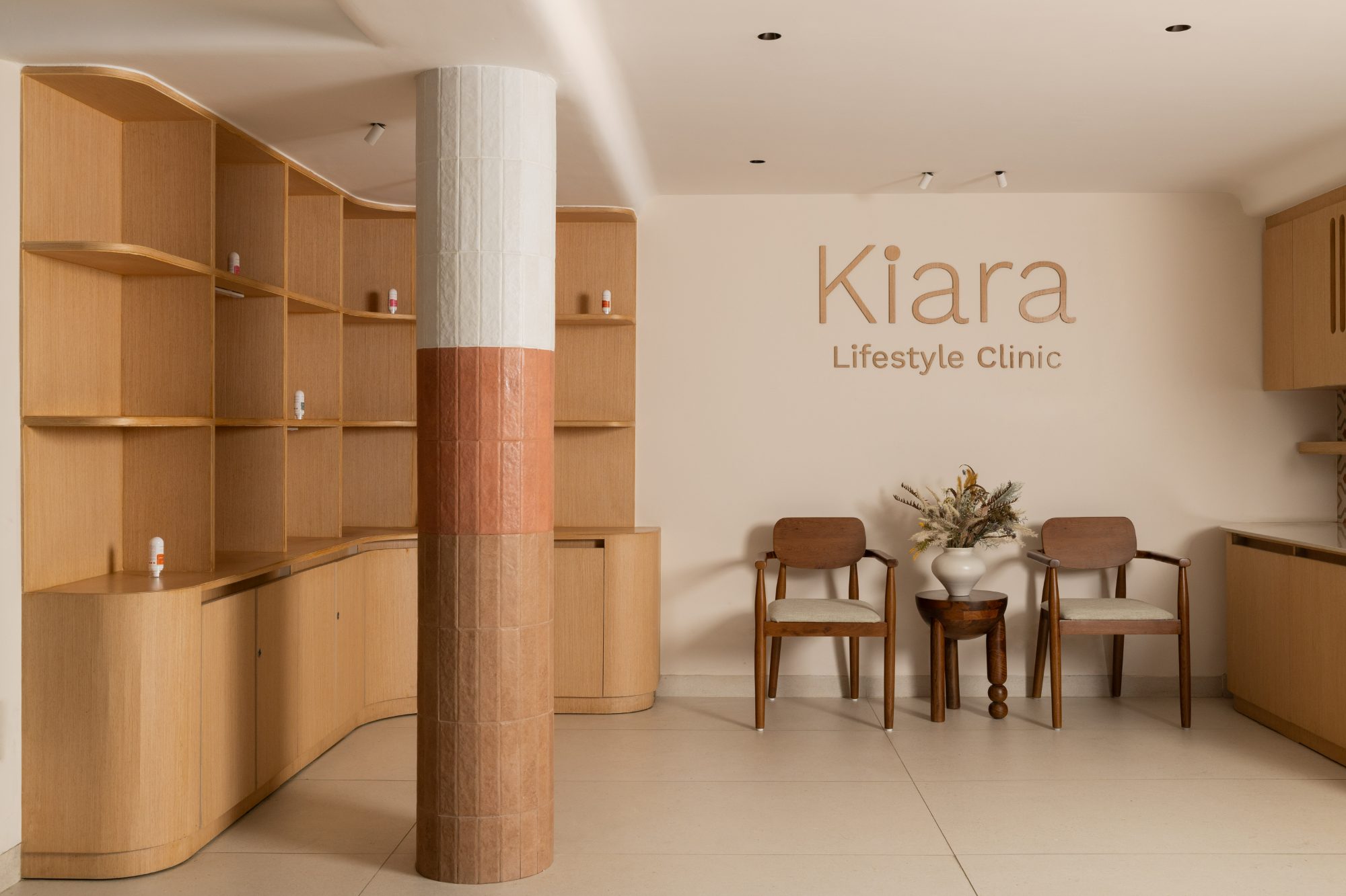 Oak display shelving beside a clay-toned column