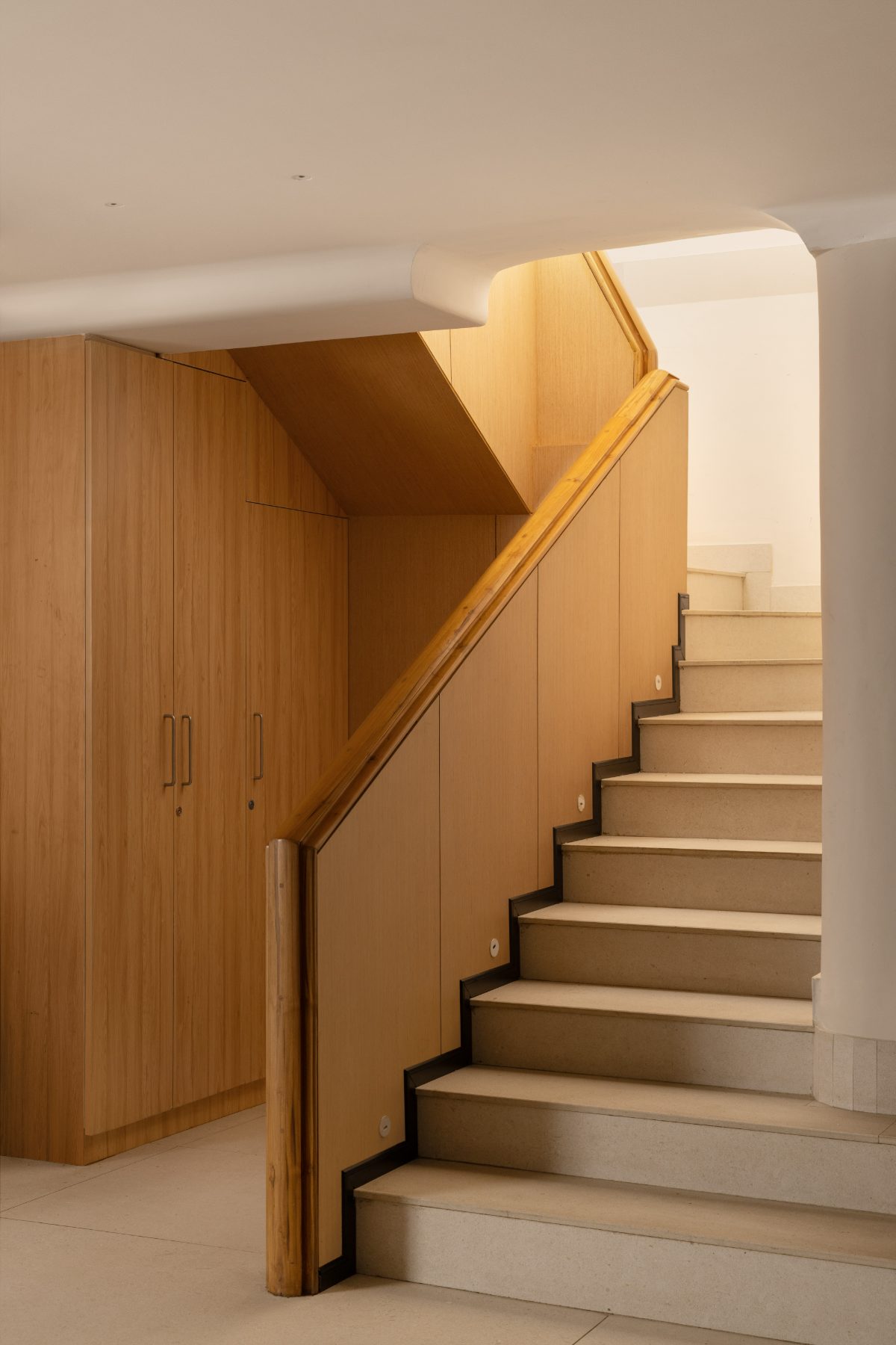 Sculptural oak and travertine staircase