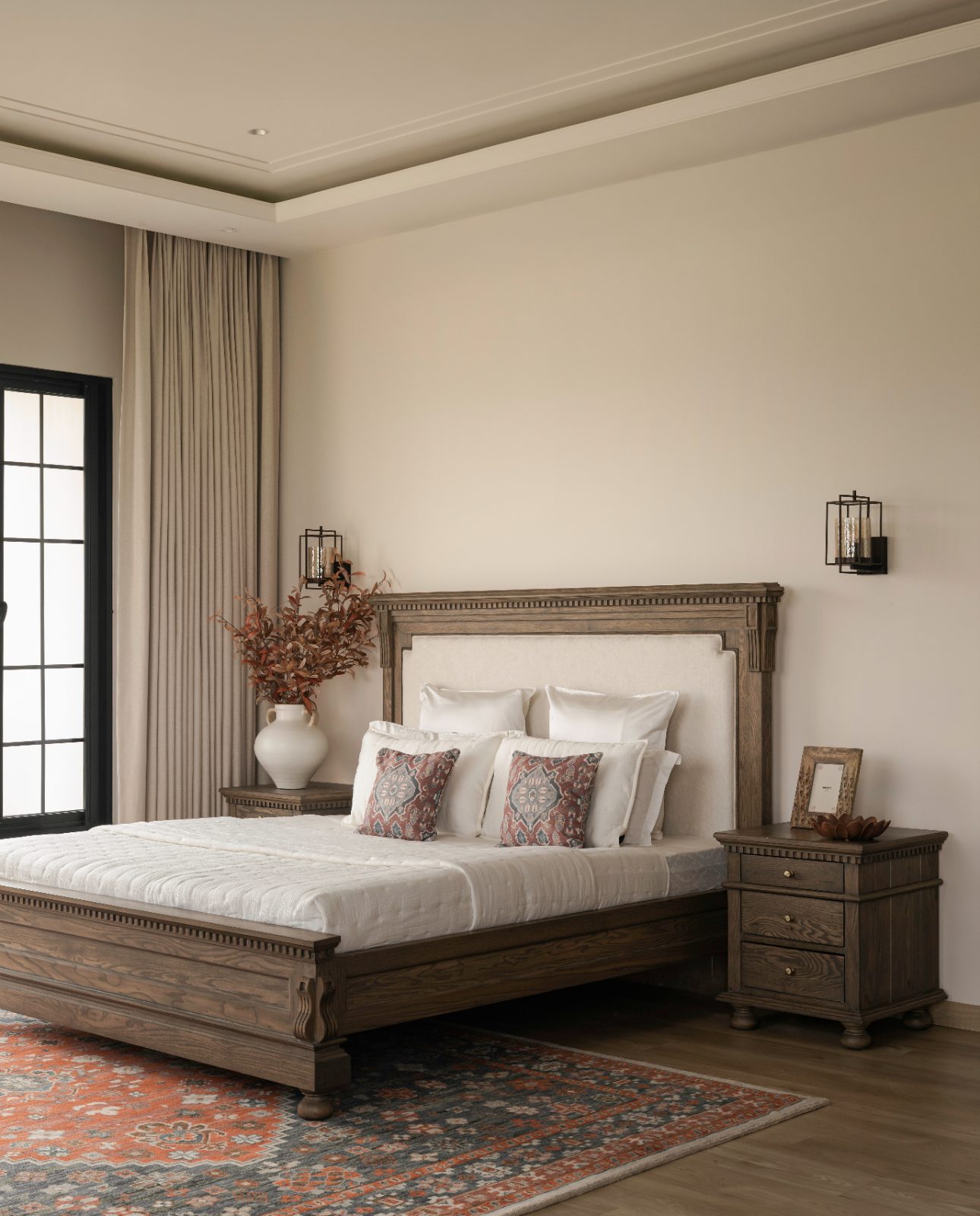 Principal bedroom with a carved dark-oak bed and kilim rug