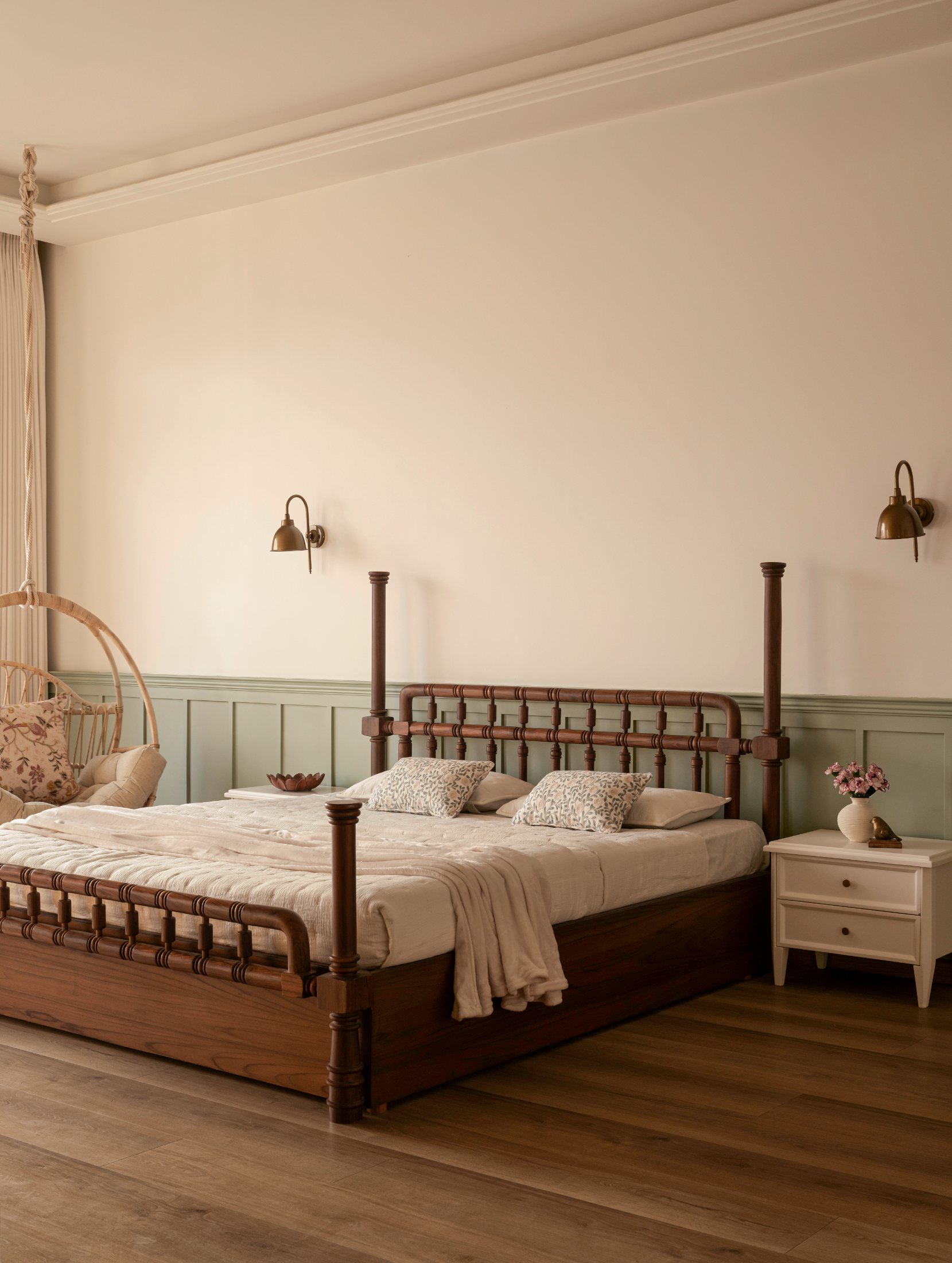 Bedroom in sage panelling with a turned four-poster and rattan swing