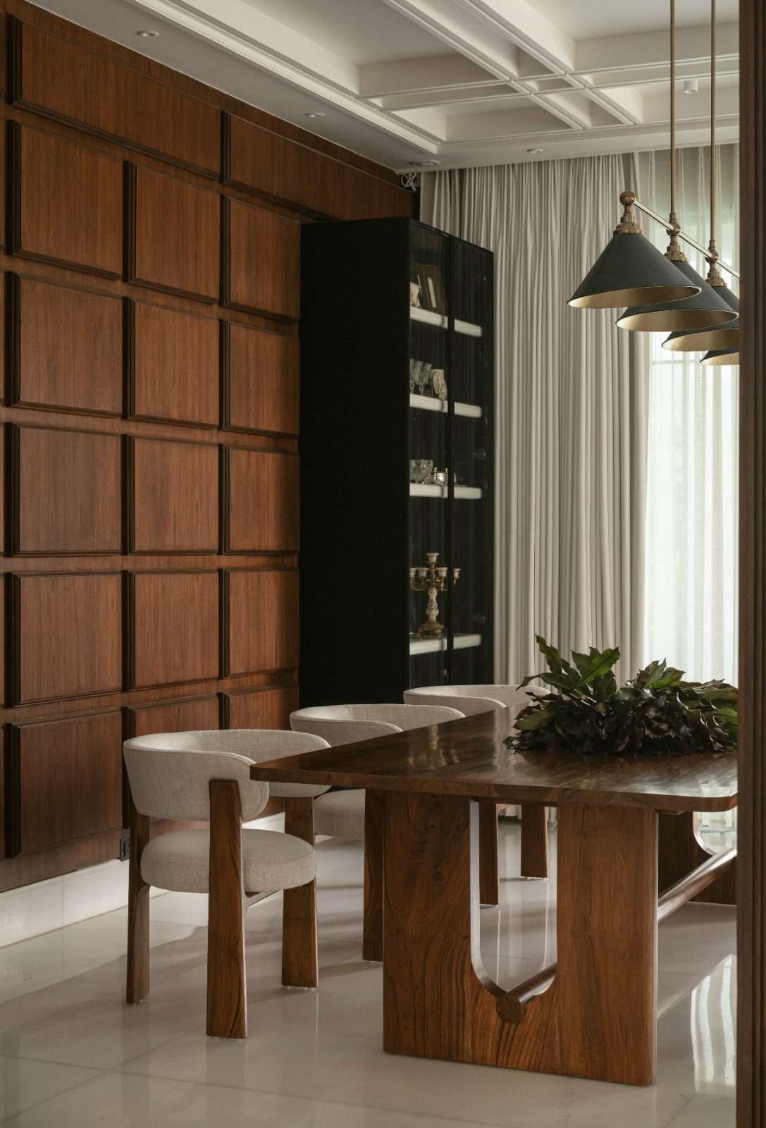 Panelled dining room with a live-edge table and black vitrine