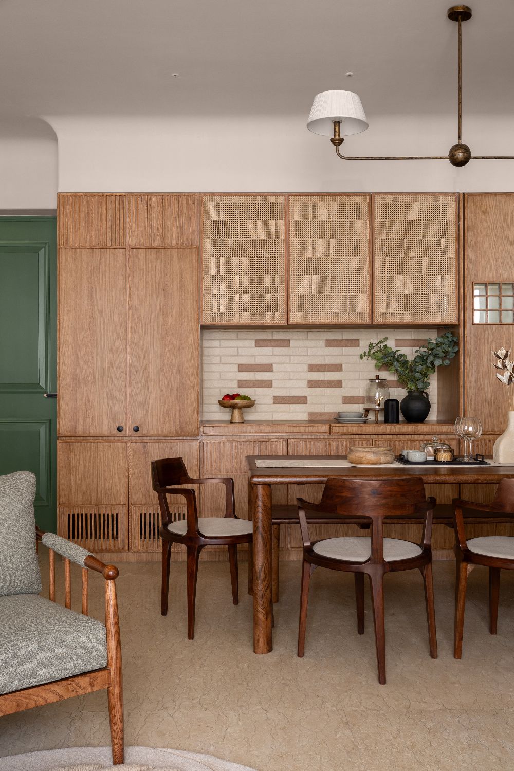 Dining with a green door, cane cabinets and hand-glazed tile