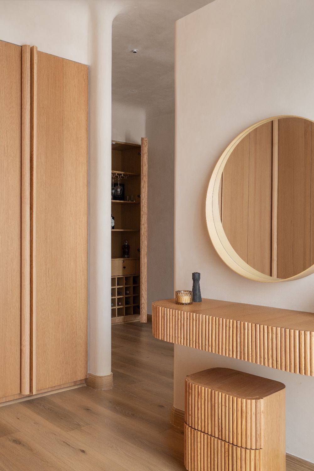 Dressing nook with a round oak mirror and fluted console