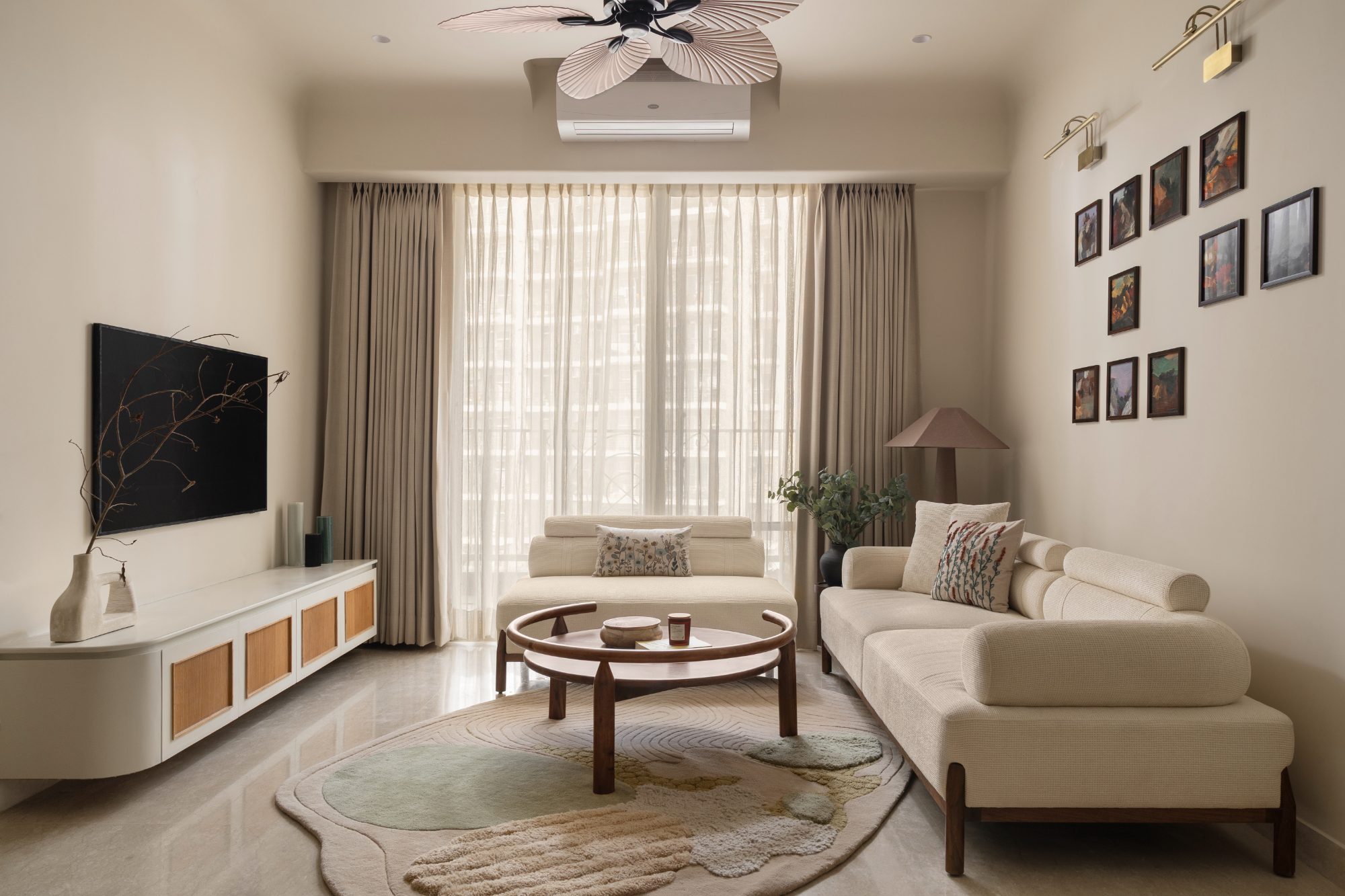 Living room with woven palm fan, curved sofa and a gallery wall