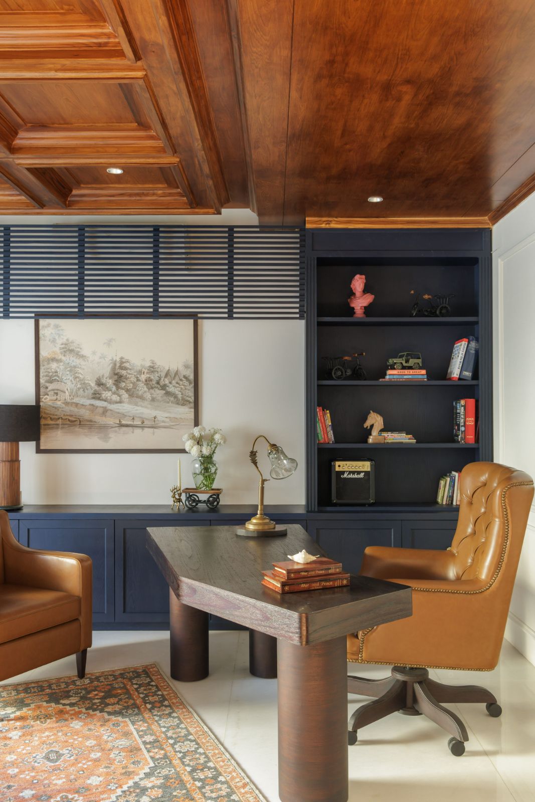 Study in deep navy with a coffered teak ceiling and leather chairs