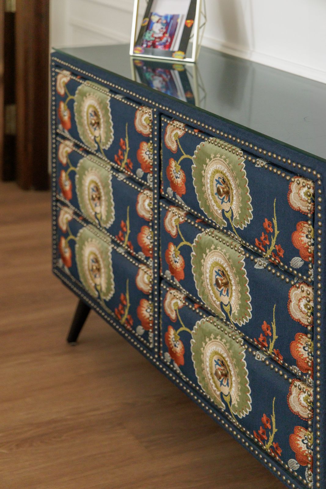 Detail of a navy floral nailhead dresser